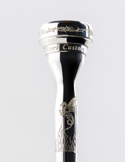 (This picture shows multiple designs) “Tribal Rim Wrap” Mouthpiece Engraving: Suitable for all trumpet, cornet, flugelhorn and trombone pieces. The cost for trumpet (etc.) is $75, $90 for trombone. “Dragon” Mouthpiece Engraving: The cost is $30 for trumpet, $35 for trombone. "Flames Wrap" Mouthpiece Engraving: The cost is $65.